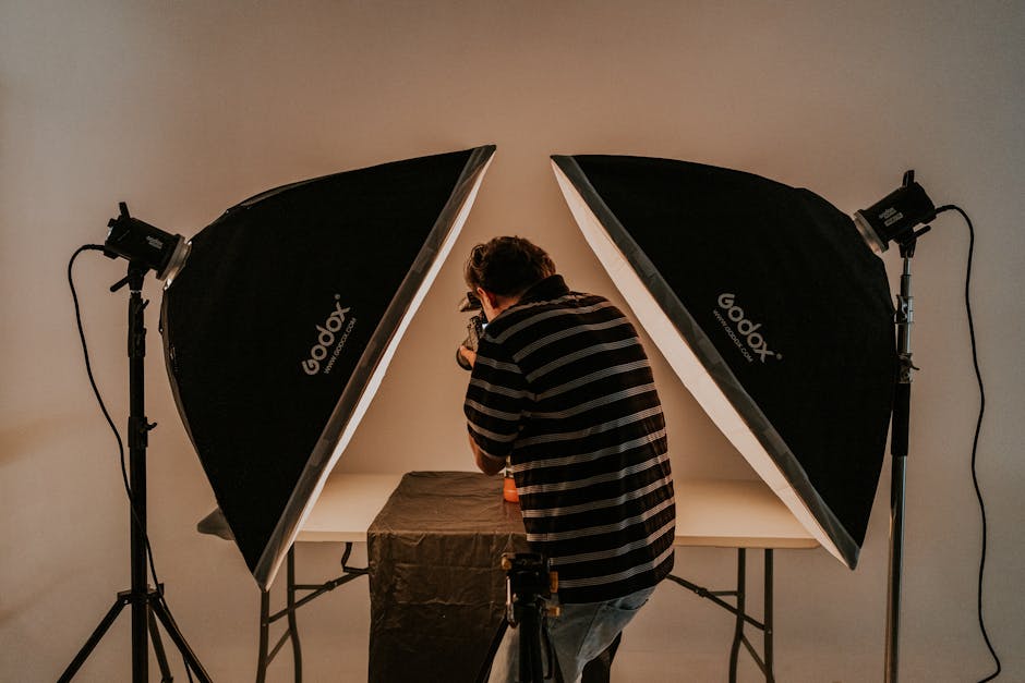 Photographer working in a studio with softbox lighting equipment.