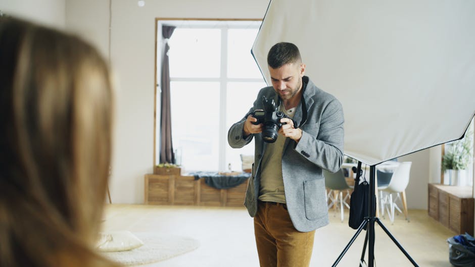 Photographer reviewing camera while setting up a shot in a studio.