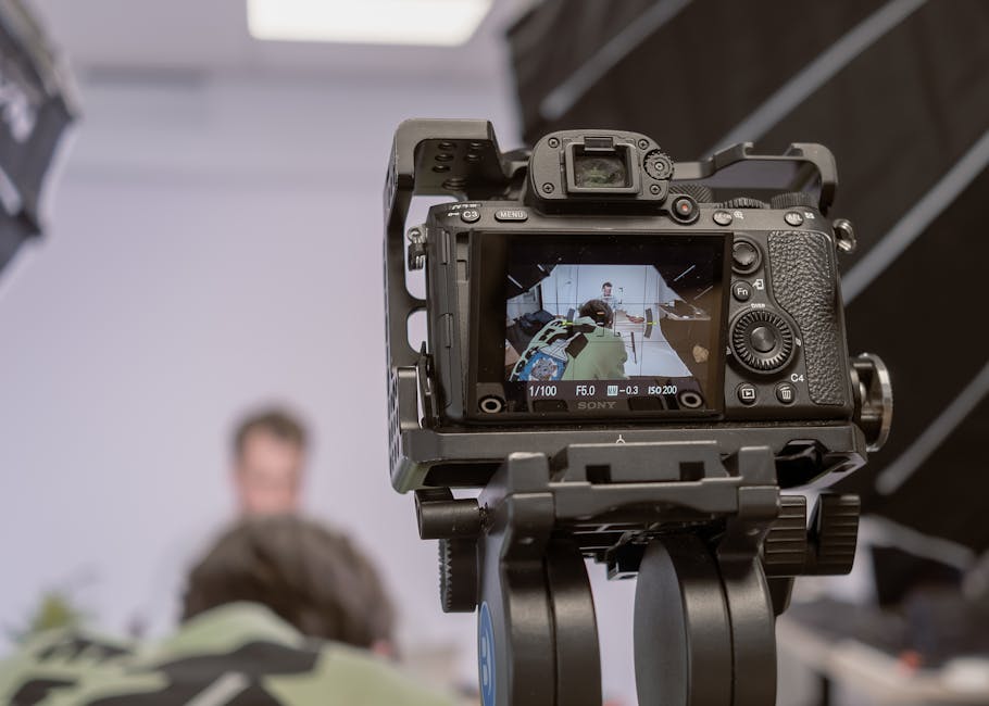 Close-up of a camera on a tripod capturing a portrait in a studio setting.